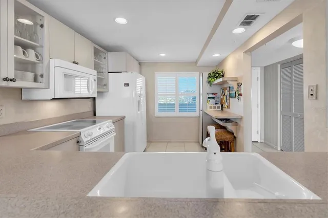 a living room with stainless steel appliances furniture a rug and a refrigerator