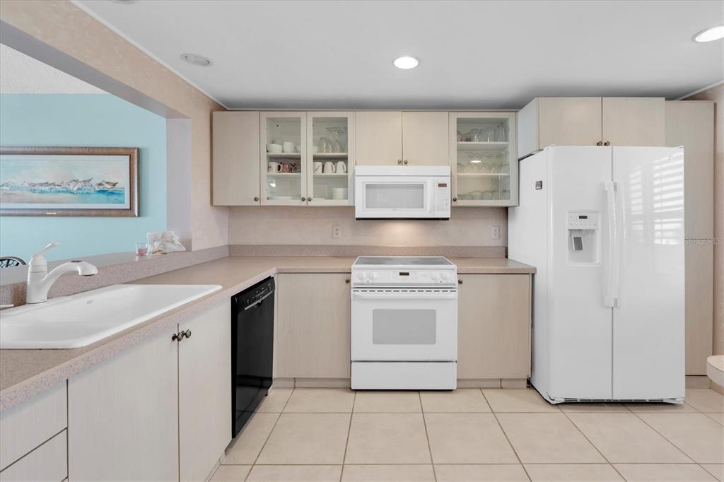 14950 Gulf Boulevard, Unit 402 Madeira Beach, FL 33708 - Photo 8 of 36 a kitchen with stainless steel appliances a refrigerator sink and cabinets