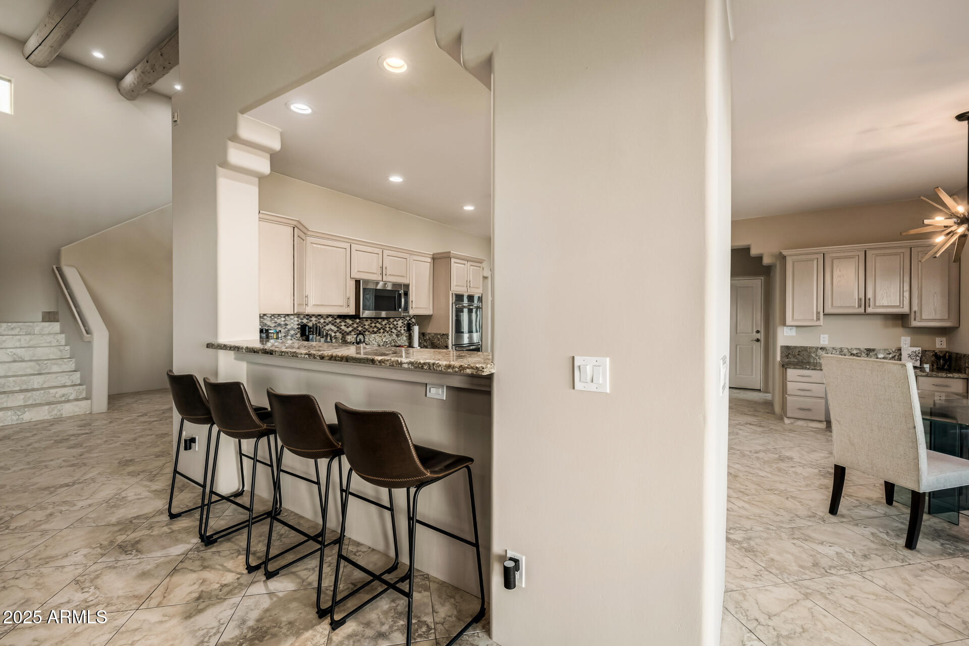 1815 West Sentinel Rock Road Phoenix, AZ 85086 - Photo 15 of 58 a kitchen with kitchen island a dining table chairs stainless steel appliances and cabinets