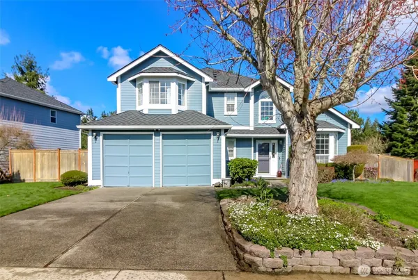a front view of a house with a yard and garage