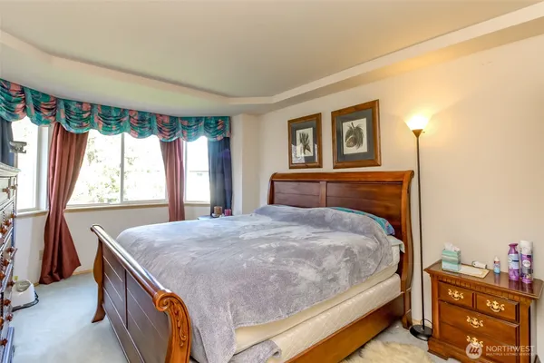 a bedroom with a bed and a dresser next to a window