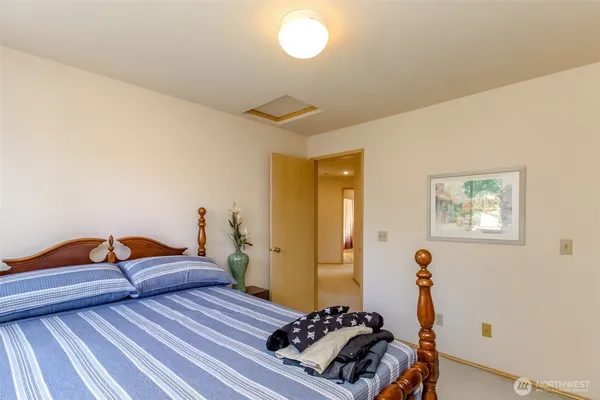 a bedroom with a bed and a lamp on the dresser