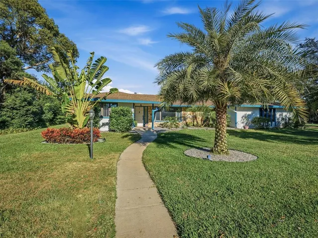 a front view of a house with a yard garden and trees