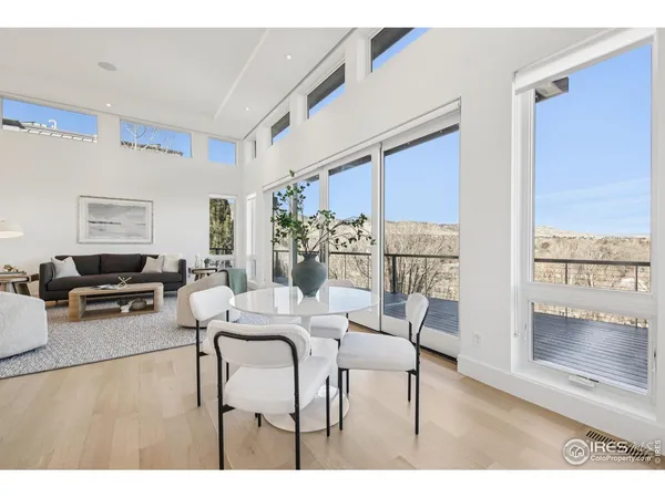 a dining room with furniture and a floor to ceiling window