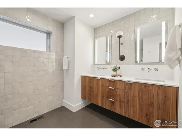 a bathroom with a double vanity sink a mirror and shower