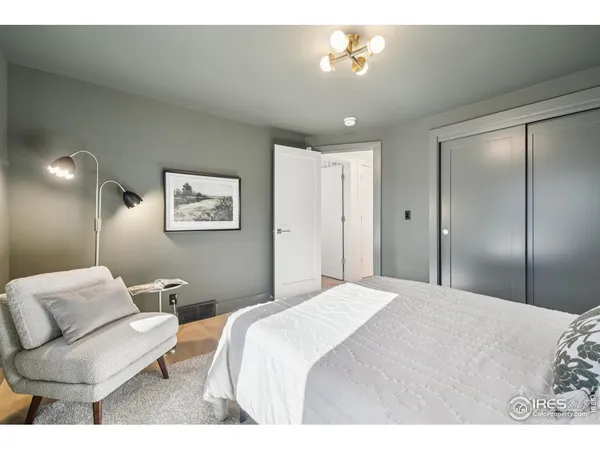 a bedroom with a bed and painting on the wall