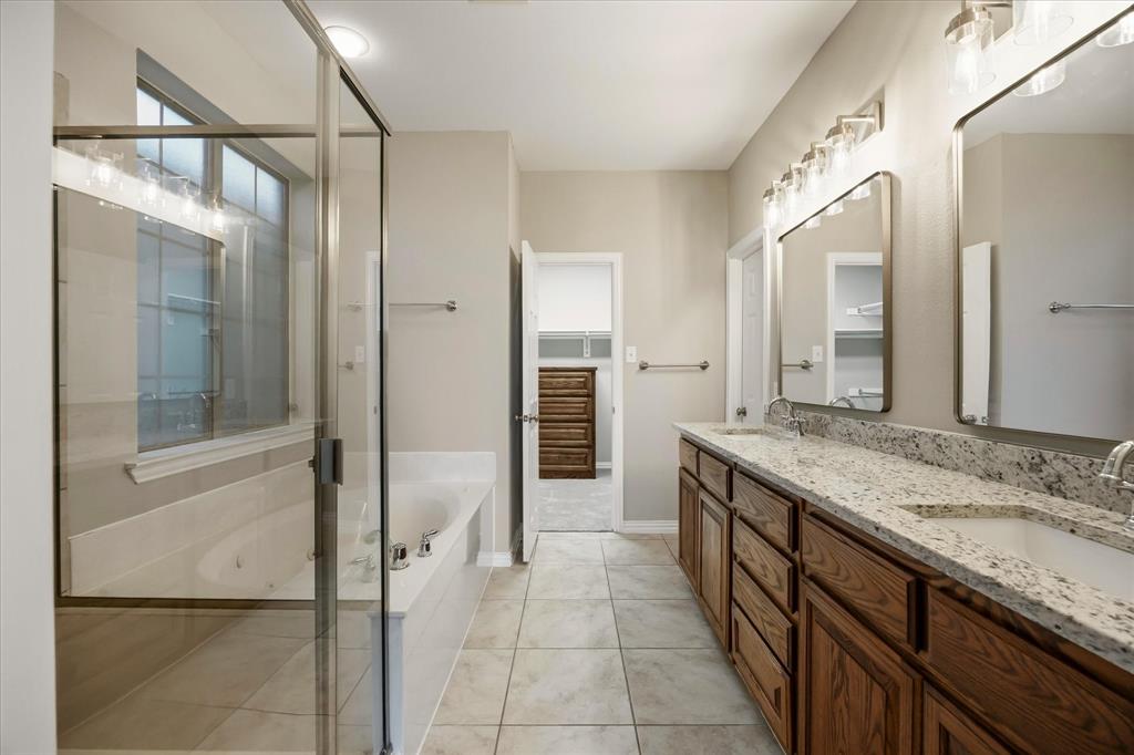 118 Stone Drive Forney, TX 75126 - Photo 13 of 26 a bathroom with a granite countertop sink mirror and a bathtub