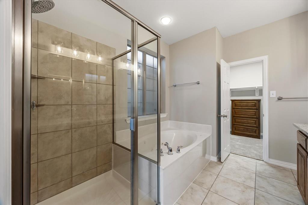 118 Stone Drive Forney, TX 75126 - Photo 14 of 26 a bathroom with a bathtub and a shower
