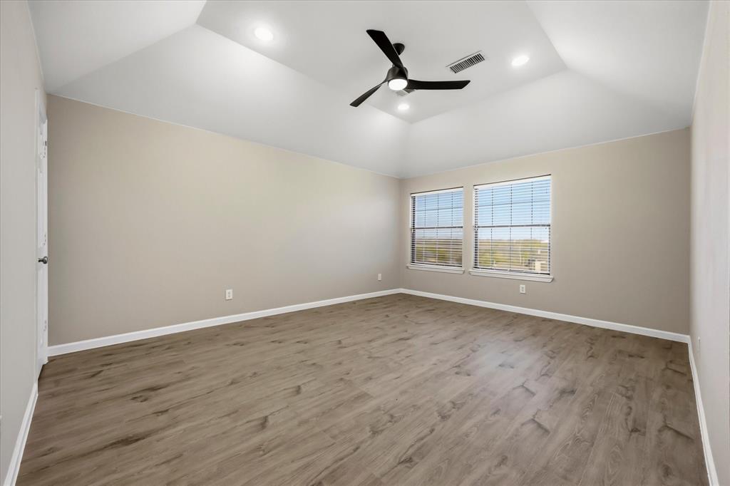 118 Stone Drive Forney, TX 75126 - Photo 17 of 26 an empty room with wooden floor ceiling fan and windows