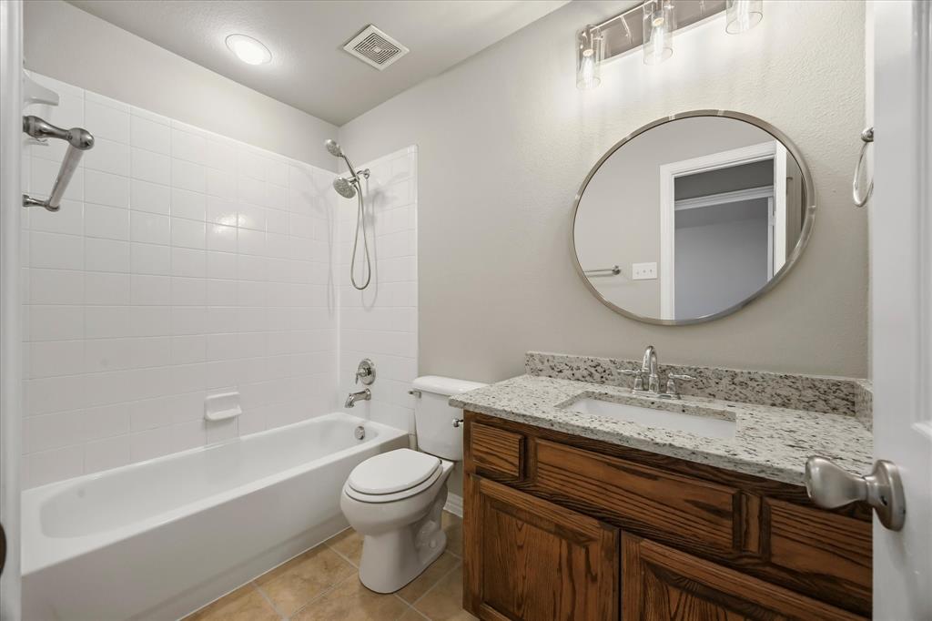118 Stone Drive Forney, TX 75126 - Photo 23 of 26 a bathroom with a granite countertop sink a toilet and a mirror