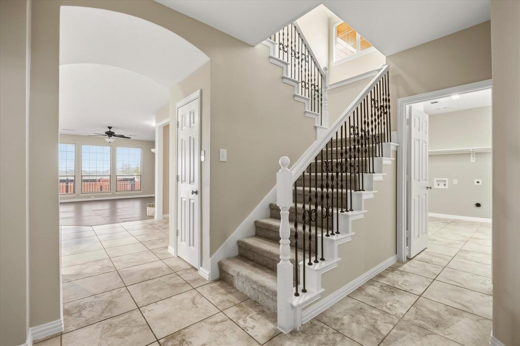 118 Stone Drive Forney, TX 75126 - Photo 5 of 26 a view of a staircase with white walls and chandelier