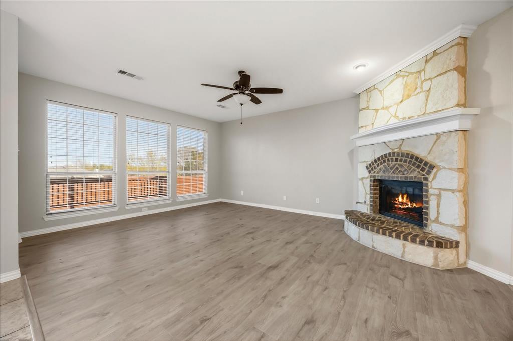118 Stone Drive Forney, TX 75126 - Photo 8 of 26 a view of a livingroom with a fireplace a ceiling fan and windows