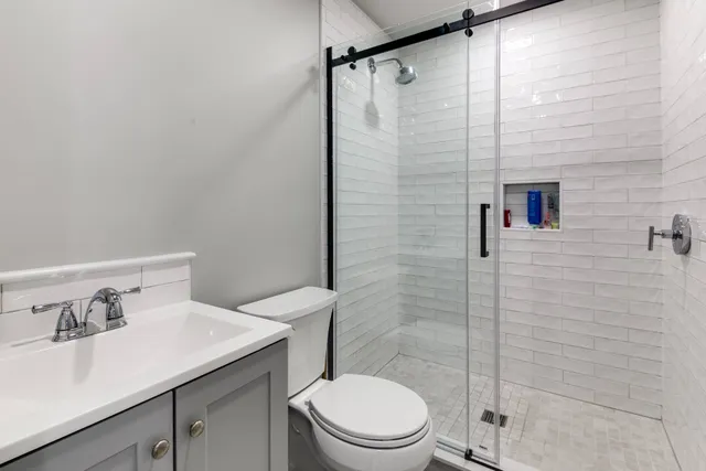 a bathroom with a sink a toilet and shower