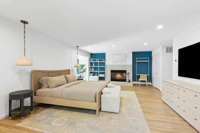 a spacious bedroom with a bed and a flat screen tv