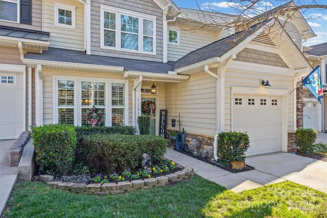 a view of a house with brick walls plants and large windows