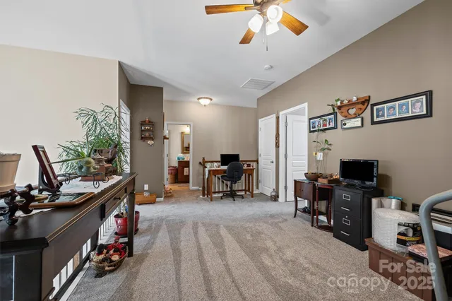 a bedroom with a bed a chandelier and a flat tv screen