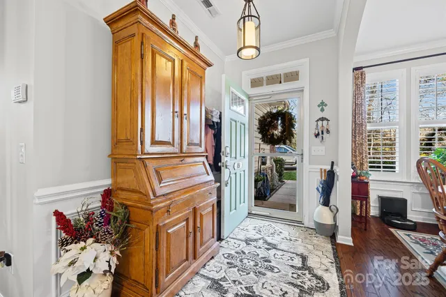 a dining room with furniture potted plants and wooden floor