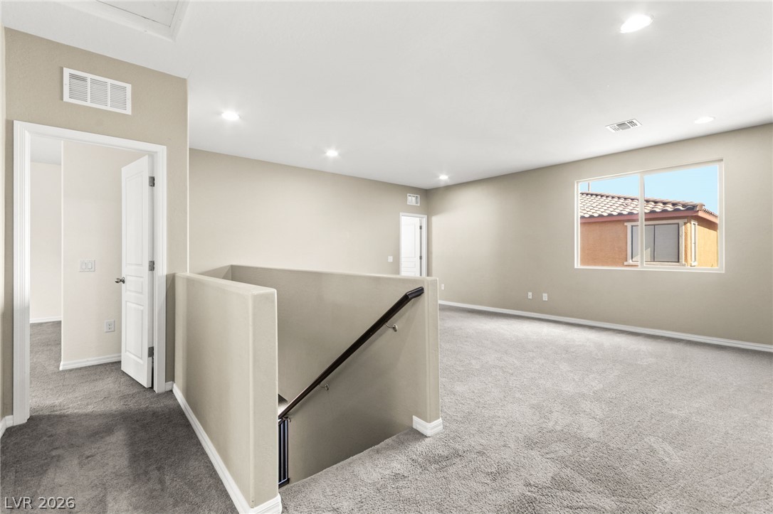 11048 Prairie Grove Road Las Vegas, NV 89179 - Photo 38 of 75 Well-lit upper level offers flexible living space with soft carpeting.