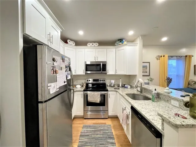 a kitchen with stainless steel appliances granite countertop a refrigerator stove microwave and sink