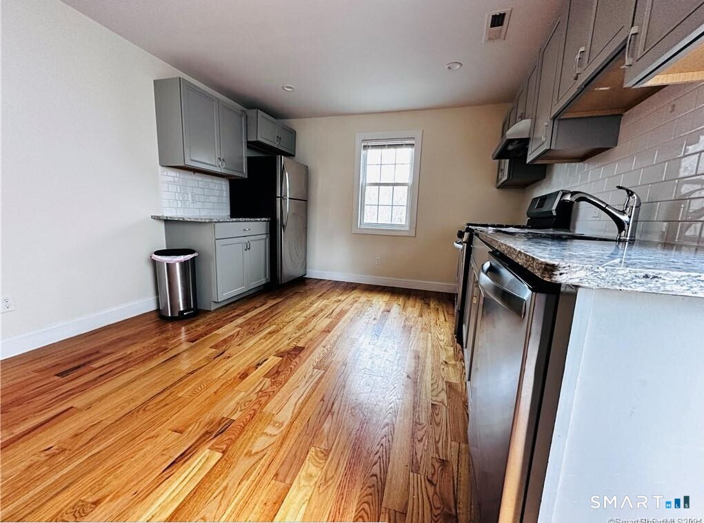 31 Brainerd Road, Unit 2 Branford, CT 06405 - Photo 2 of 15 a kitchen with a refrigerator wooden floor and a sink
