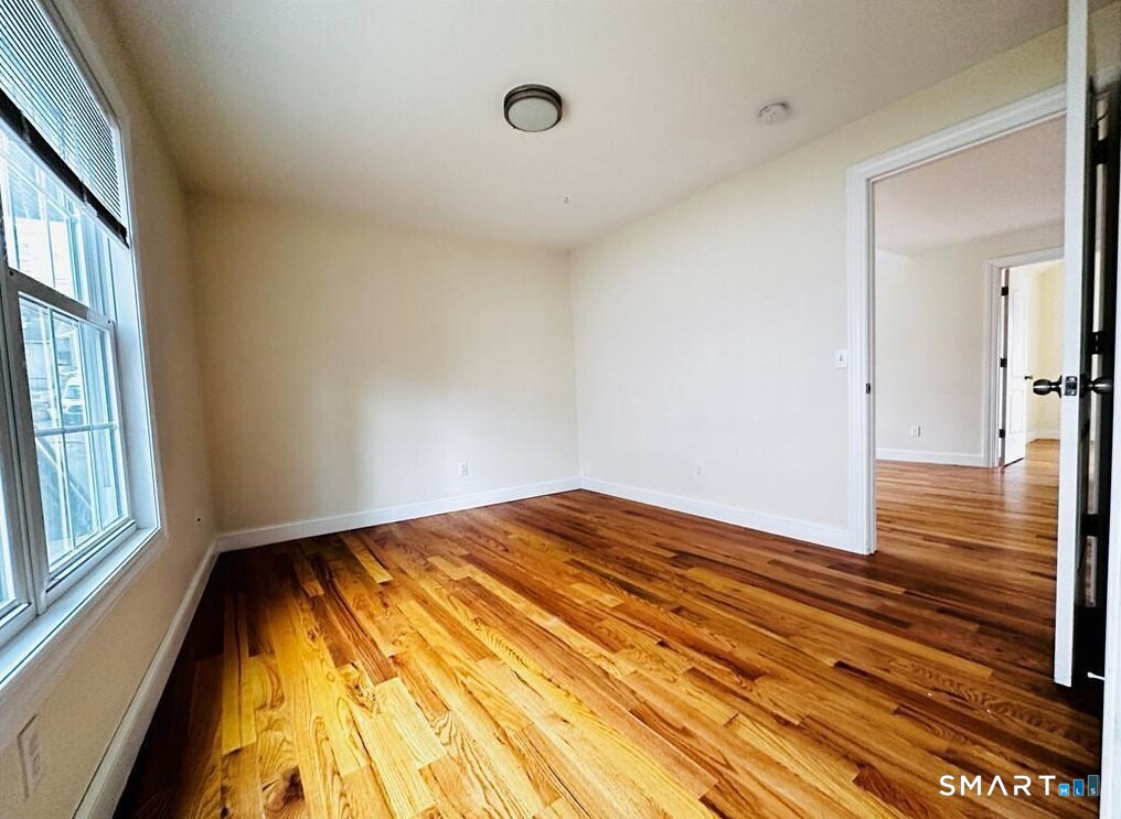 31 Brainerd Road, Unit 2 Branford, CT 06405 - Photo 9 of 15 a view of empty room with wooden floor and fan