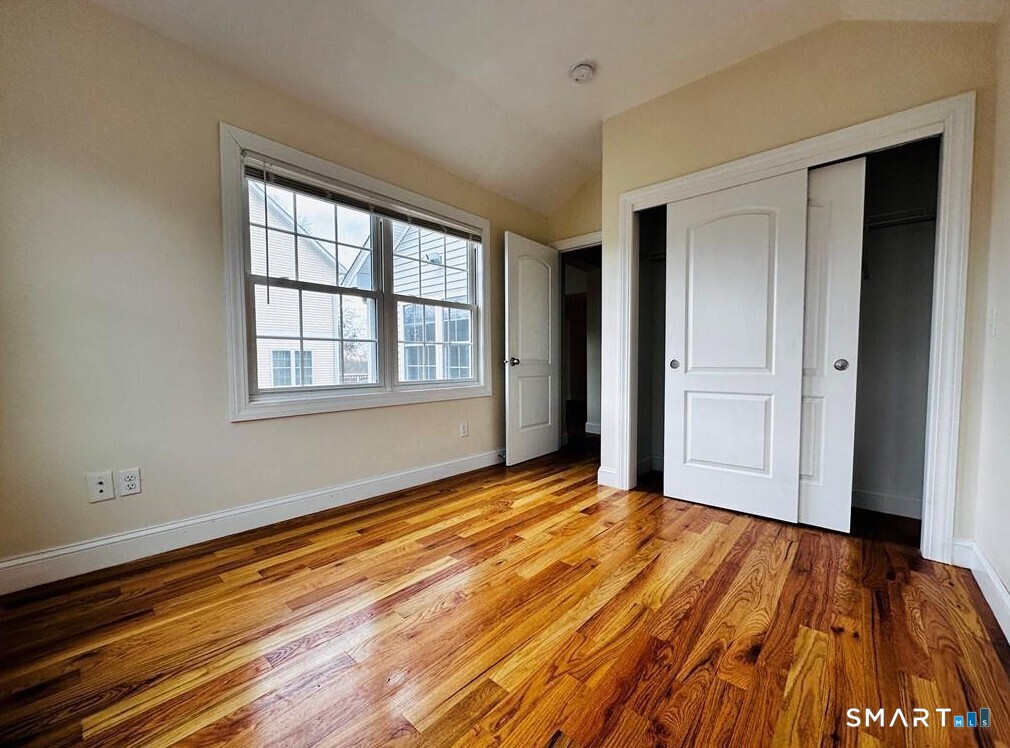 31 Brainerd Road, Unit 2 Branford, CT 06405 - Photo 10 of 15 a view of an empty room with wooden floor and a window
