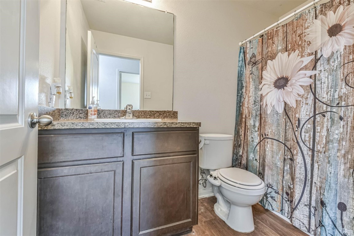 2050 Wilde Elm Houston, TX 77090 - Photo 18 of 19 a bathroom with a granite countertop toilet sink and mirror