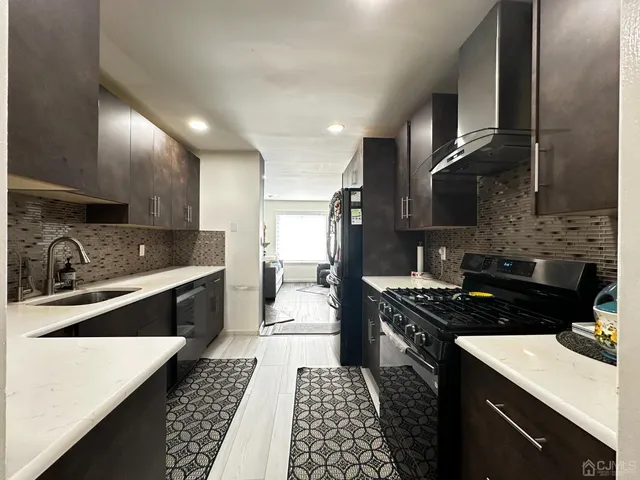 a kitchen with stainless steel appliances a sink stove and cabinets
