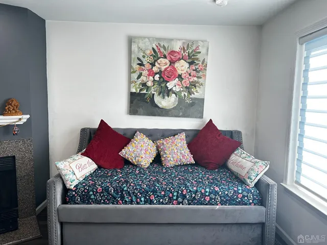 a bed sitting in a bedroom next to a window with painting on the wall