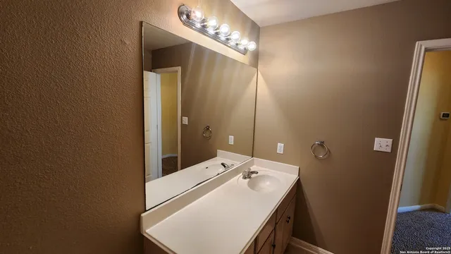 an empty room with a chandelier fan and windows