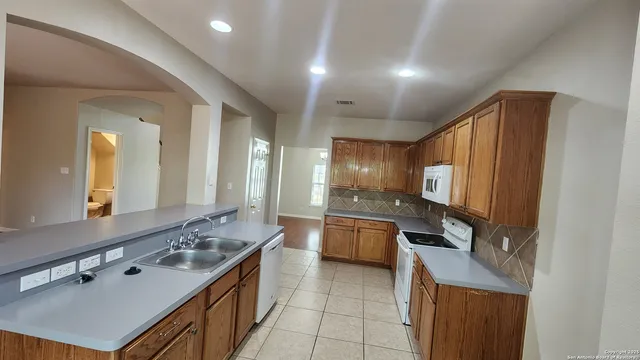 a large kitchen with kitchen island a sink stove and refrigerator
