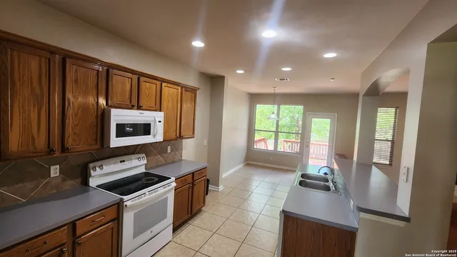 a kitchen with stainless steel appliances a stove sink microwave and cabinets