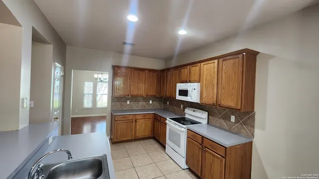 a kitchen with stainless steel appliances granite countertop a sink stove and cabinets