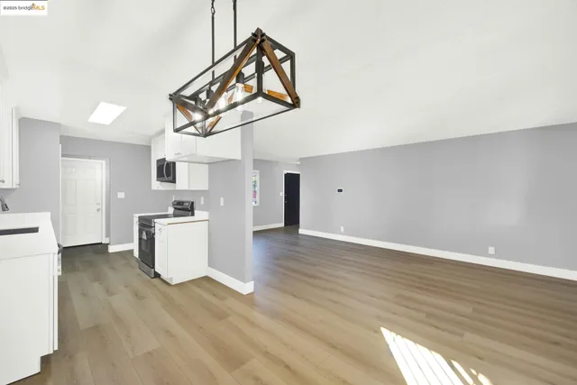 a view of a kitchen with wooden floor and a refrigerator
