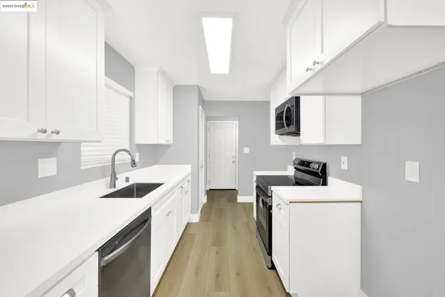 a kitchen with stainless steel appliances granite countertop a sink and a refrigerator