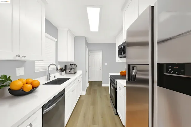 a kitchen with a sink cabinets and wooden floor