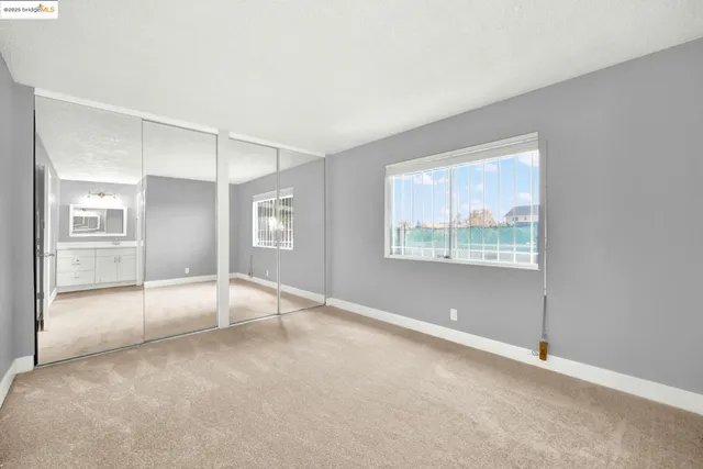 a bedroom with two beds and large window