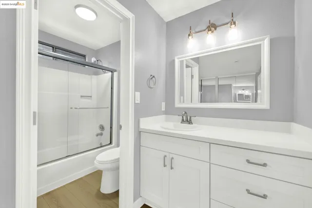 a bathroom with a sink vanity mirror and toilet
