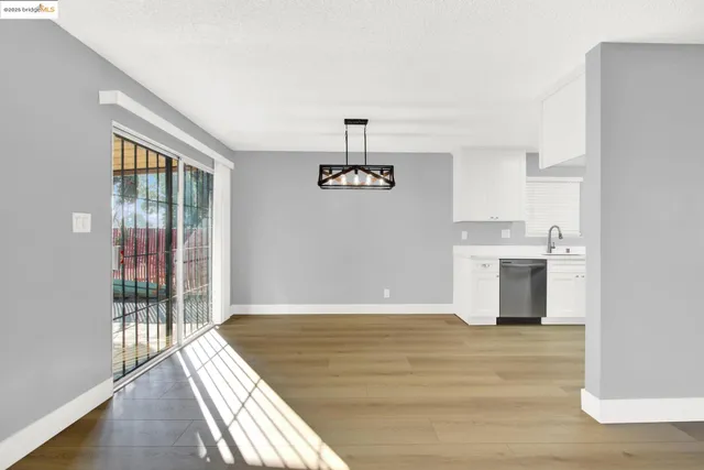 a view of a kitchen with wooden floor and a ceiling fan
