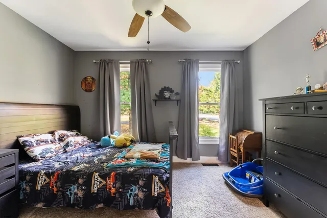 a living room with a bed furniture and a flat screen tv