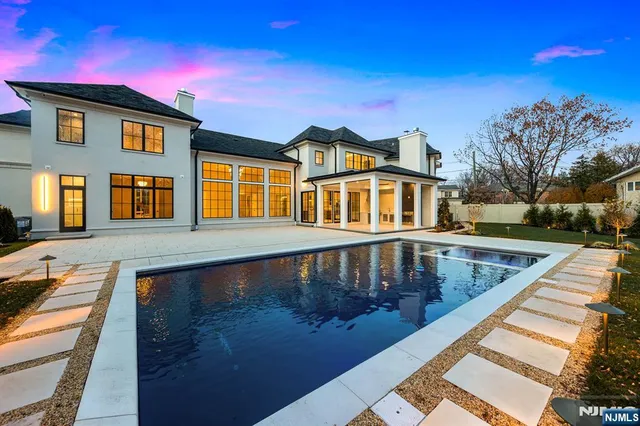 a view of swimming pool with lawn chairs and potted plants