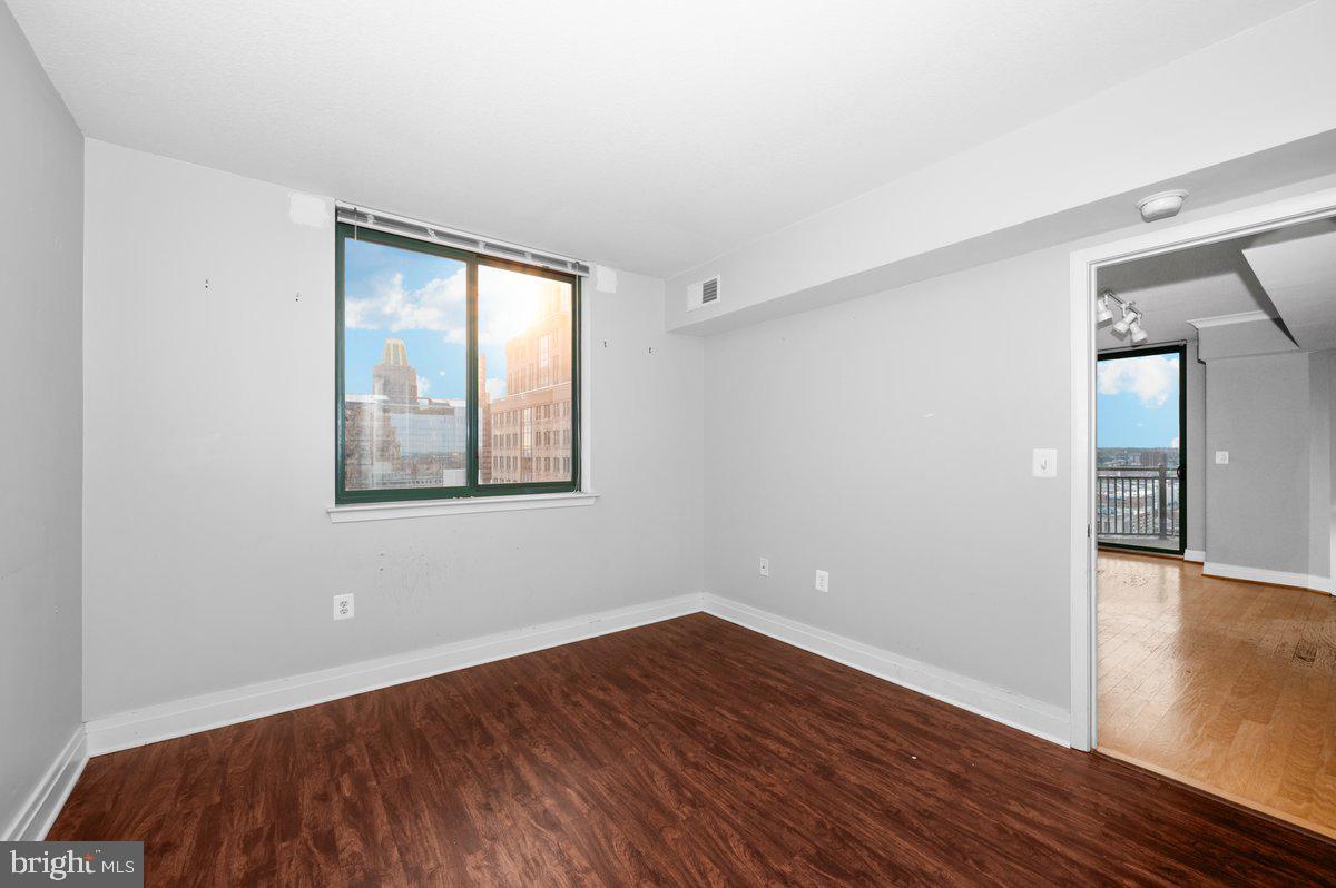 414 Water Street, Unit 2805 Baltimore, MD 21202 - Photo 17 of 26 a view of an empty room with wooden floor and a window