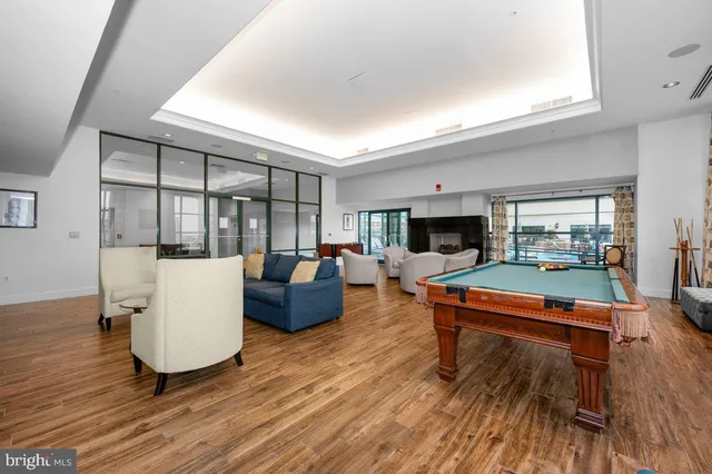 a living room with furniture a flat screen tv and a wooden floor