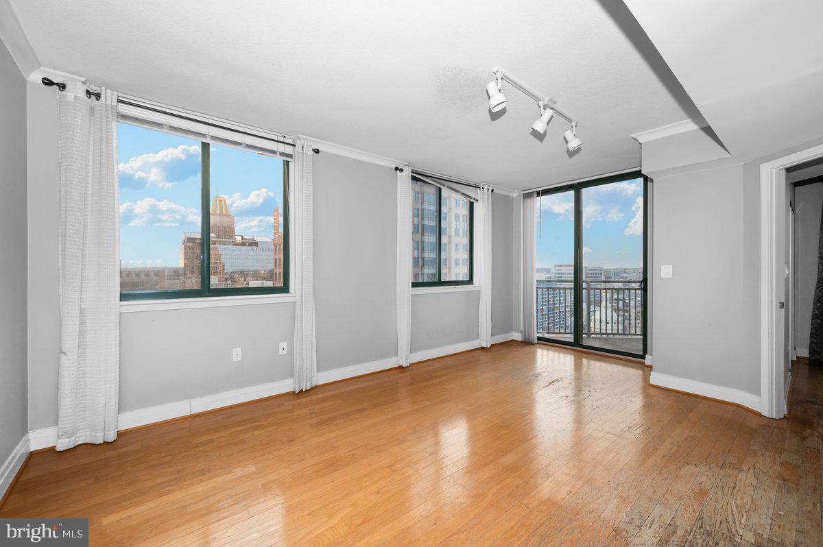 414 Water Street, Unit 2805 Baltimore, MD 21202 - Photo 10 of 26 a view of an empty room with a window and wooden floor