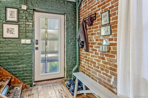 a living room with furniture a flat screen tv and a refrigerator