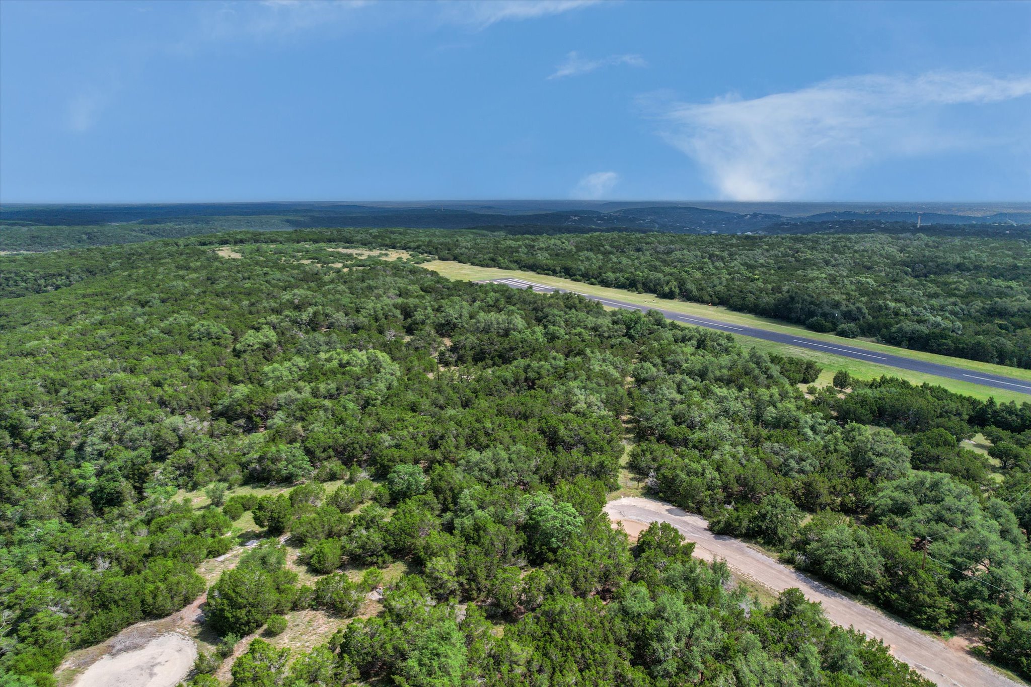 9404 Bar K Ranch Road Leander, TX 78645 - Photo 7 of 12 Vast, verdant landscape unfolds with a private airstrip cutting through the dense forest.