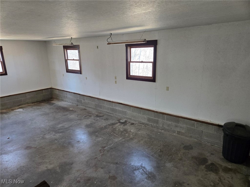 6376 Nichols Road Malta, OH 43758 - Photo 13 of 23 Spare room with a healthy amount of sunlight, a textured ceiling, and concrete flooring