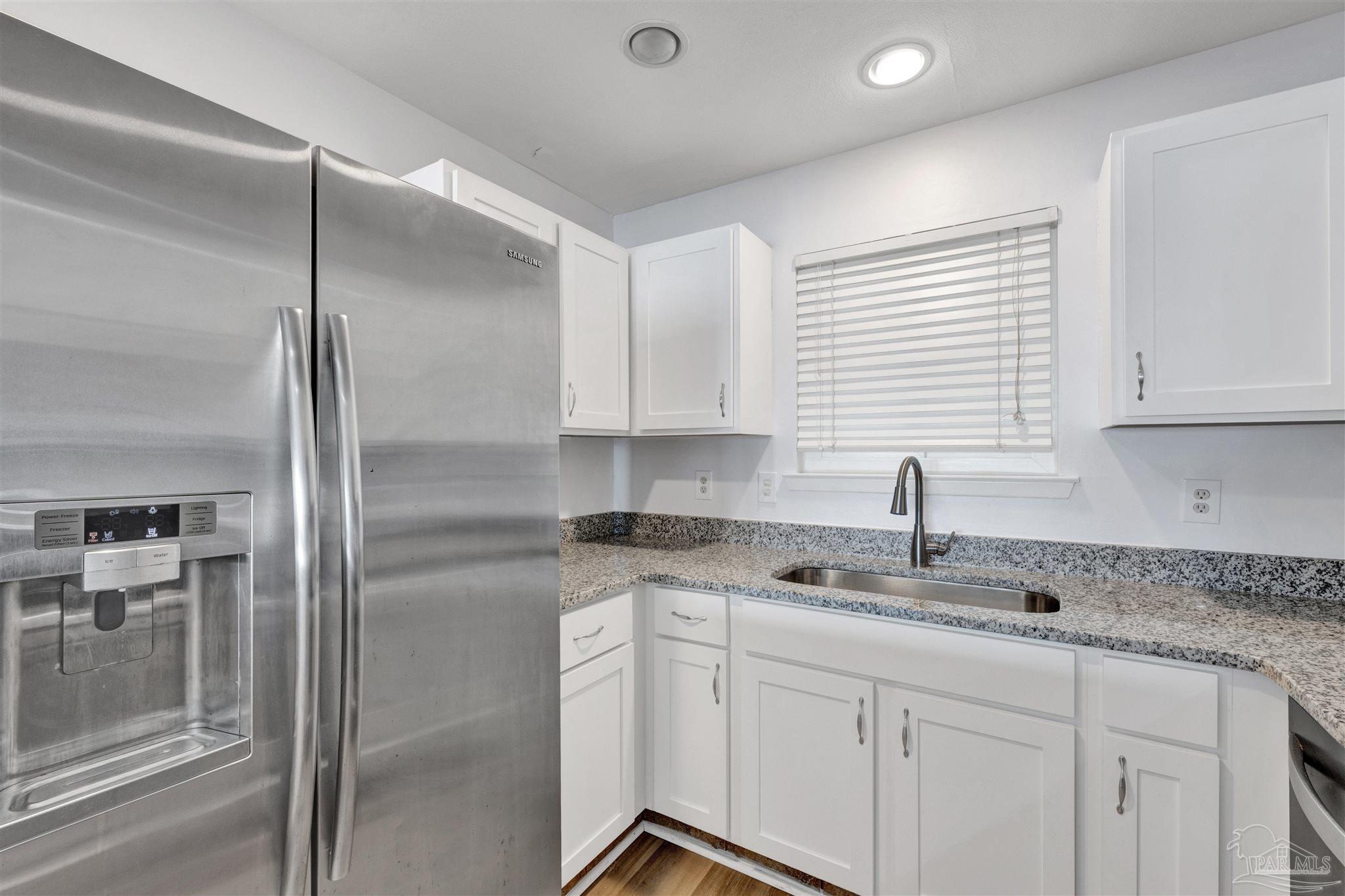 14100 River Road, Unit 334 Perdido Key, FL 32507 - Photo 15 of 35 a kitchen with stainless steel appliances granite countertop a sink and refrigerator