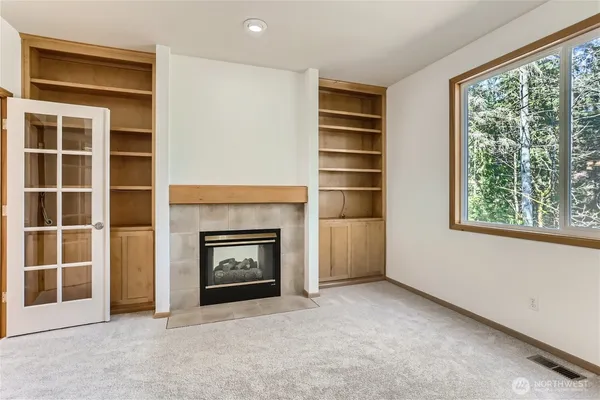 a view of an empty room with a window and fireplace