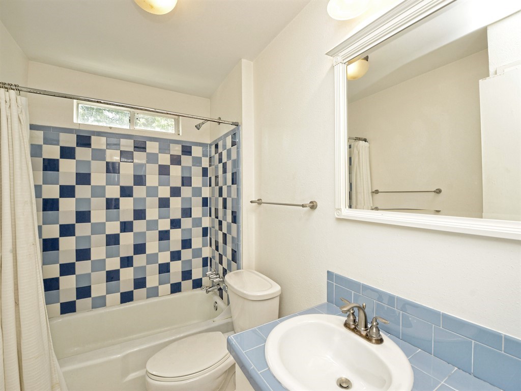 604 Franklin Boulevard, Unit A Austin, TX 78751 - Photo 16 of 20 a bathroom with a sink a toilet and shower curtain